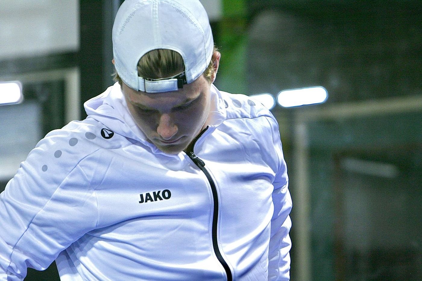Close up of Matteo in a white JAKO hooded jacket, head down between points