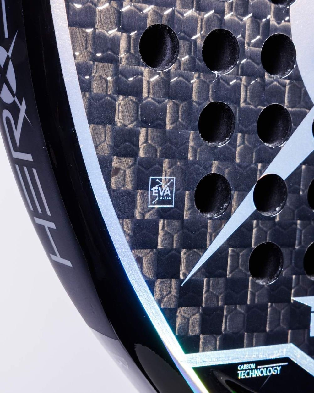 Close-up of the racket face: woven 12K carbon, drilled holes, and the EVA Black core stamp